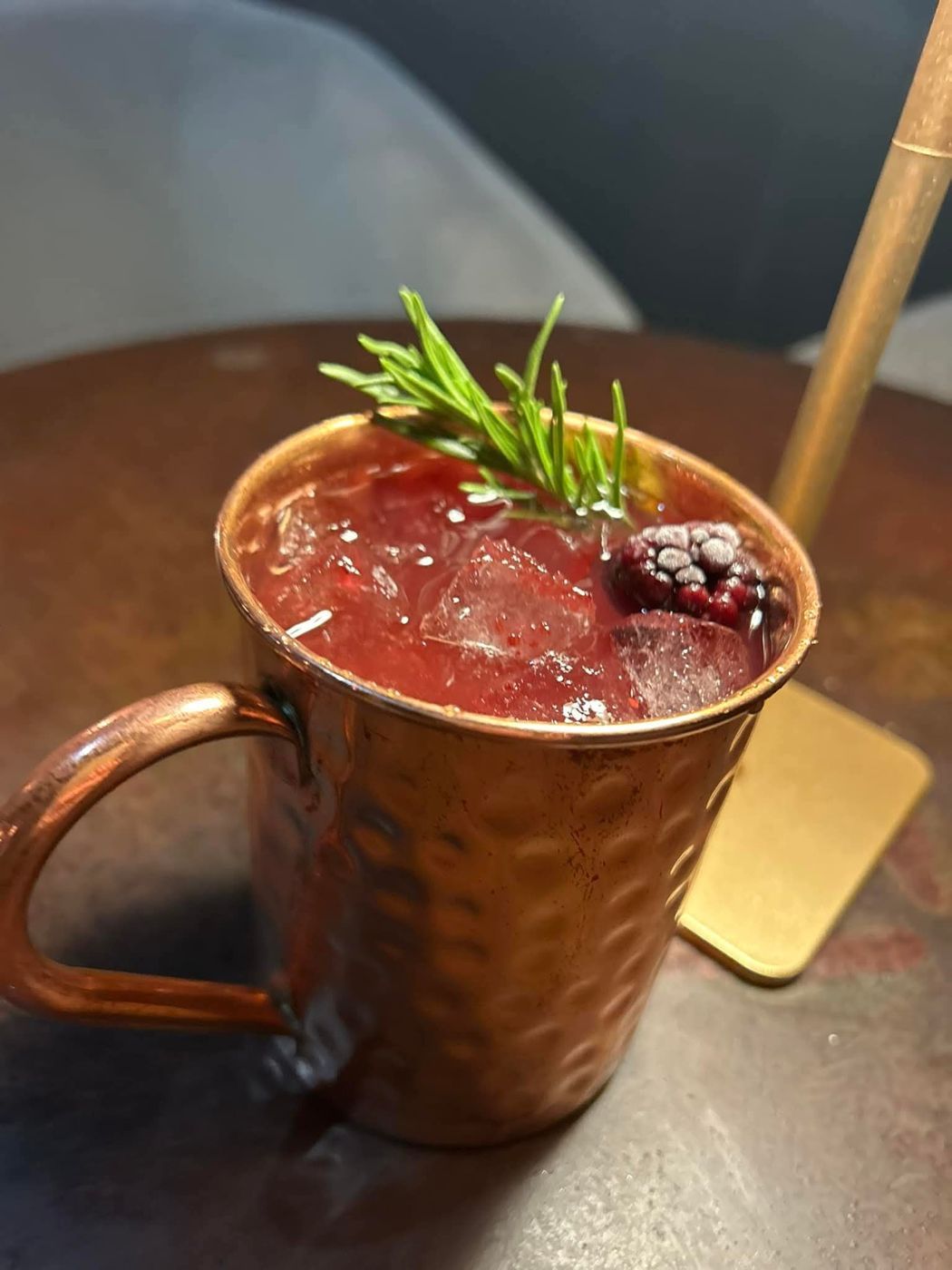 Frosted Blackberry Bourbon Mule in a copper mug with rosemary