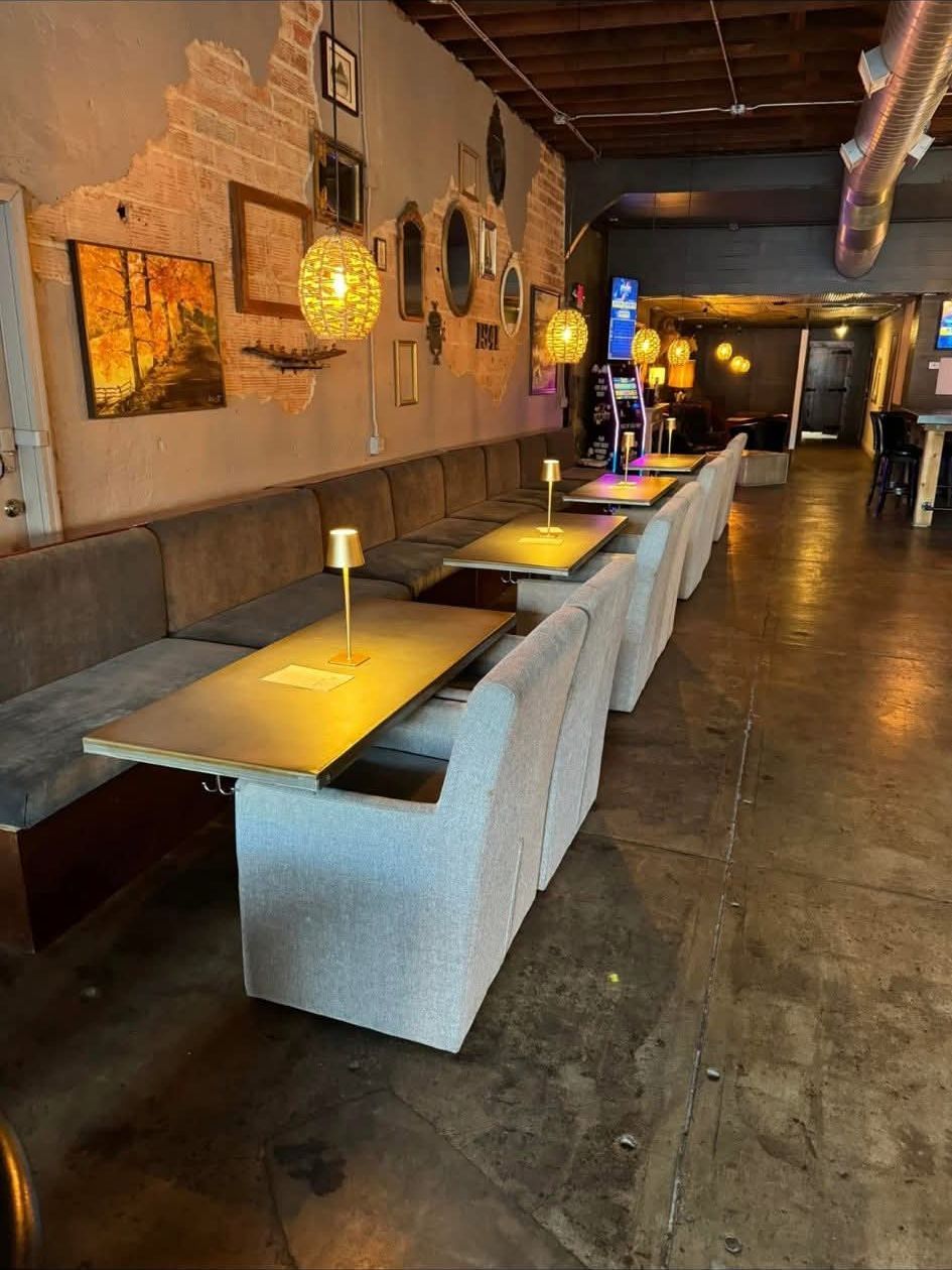 Long banquette under woven pendant lights and the 1941 wall