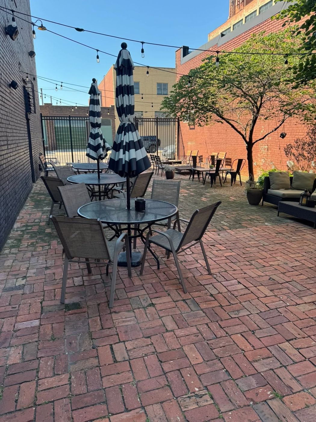 Striped umbrella tables on the herringbone brick patio