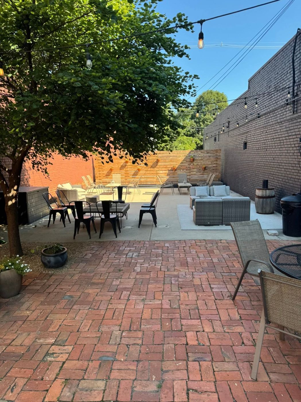 The Reno Tavern brick patio with string lights, umbrella tables and lounge seating