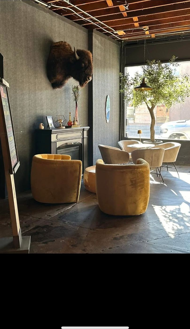 Velvet swivel chairs by the fireplace under a bison mount